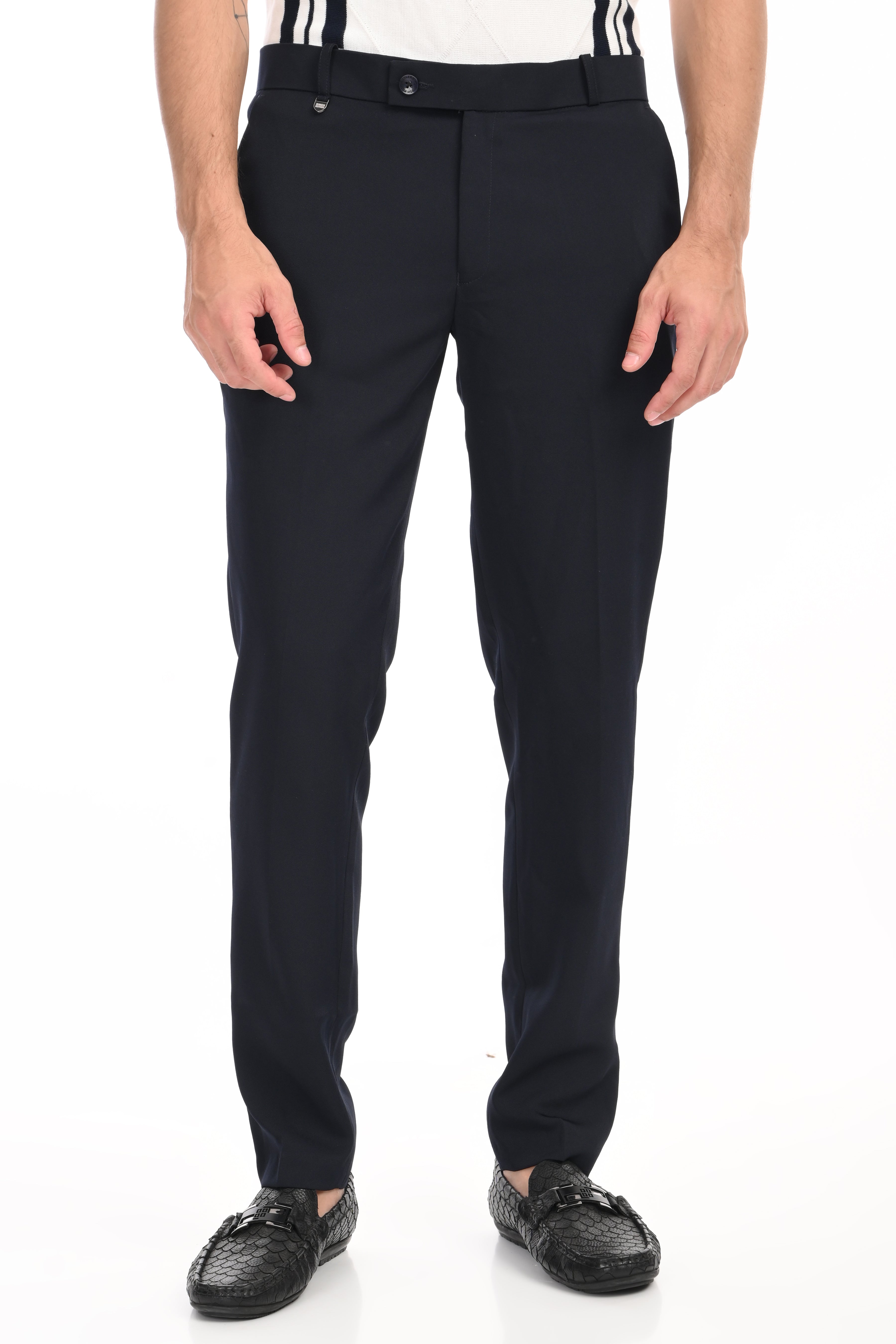 Black dress pants worn by a person on a white background